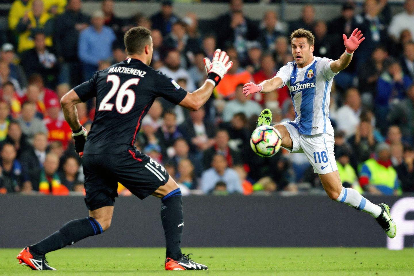 Two soccer players competing for ball midair on field