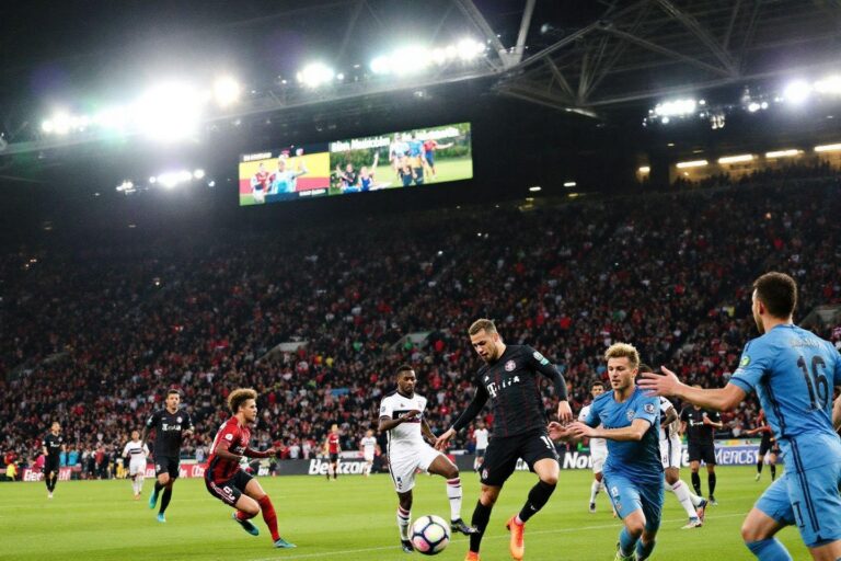 Soccer players competing for ball under bright stadium lights